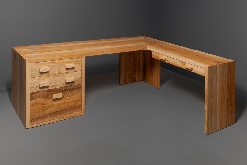Handcrafted L-shaped solid wood desk with drawers, showcasing sustainable custom woodworking and natural wood grain finish.