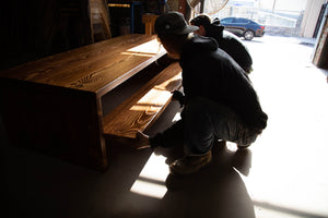 Two workers constructing custom wood furniture