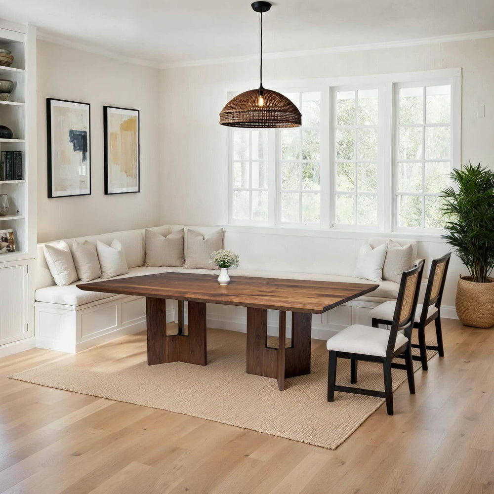 Light-filled dining room with handcrafted solid wood double pedestal table and cozy built-in seating.