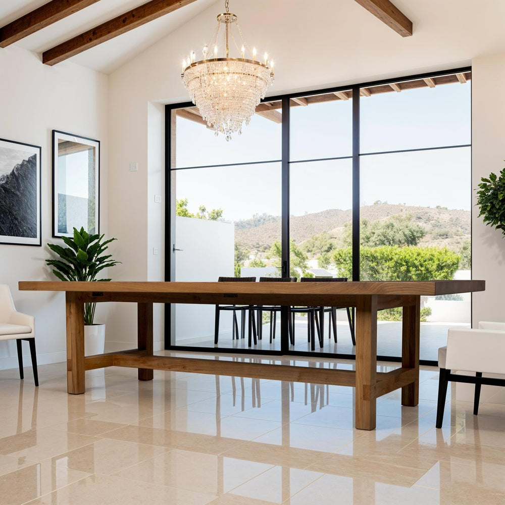 Spacious handcrafted solid wood dining table in a bright room with large windows and natural light