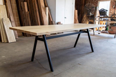 Long, wooden table with black frames and legs